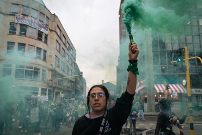 Una mujer sostiene una bengala verde durante la conmemoración.