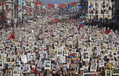 Manifestantes muestran retratos de sus antepasados, participantes de la II Guerra Mundial, mientras celebran el 70 aniversario de la derrota de los nazis, en San Petersburgo, Rusia. Cerca de 100.000 personas caminaron por las calles centrales en una marcha denominada ' Regimiento Immortal".