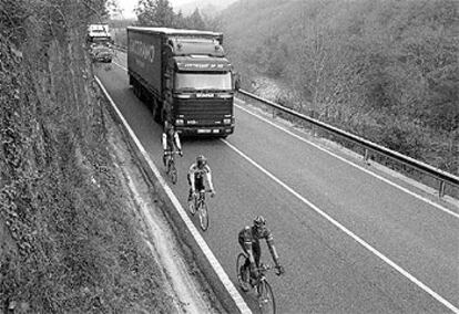 Un grupo de ciclistas a punto de   ser adelantados por un camión.