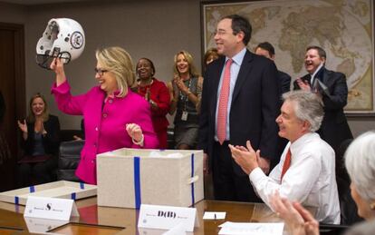 La secretaria de Estado, Hillary Clinton, muestra el regalo recibido este lunes de parte de sus asesores.