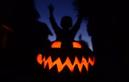 Todo preparado para pasar una noche de terror en EE UU. Niños juegan tras una calabaza en California.