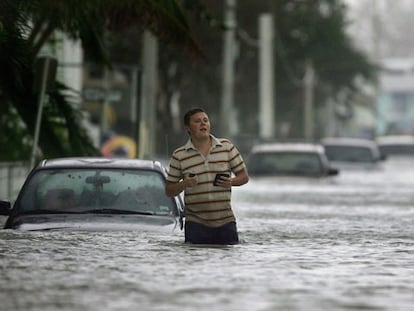 Un habitante de Cayo Hueso (Florida) camina por una calle anegada tras el paso del huracán Wilma.