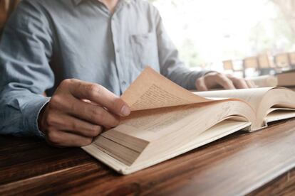 Un hombre leyendo un libro.