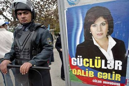 Un policía, ante un cartel electoral en el centro de Bakú.