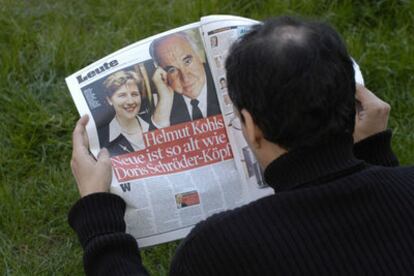 Un hombre lee la página del diario <i>Bild Zeitung</i> en la que Helmut Kohl confirma su noviazgo.