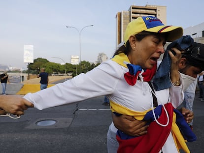 Uma opositora ao regime de Maduro depois do lançamento de gás lacrimogêneo, nesta terça-feira em Caracas.