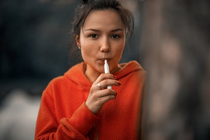 Una mujer utilizando un dispositivo calentador de tabaco.