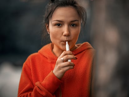 Una mujer utilizando un dispositivo calentador de tabaco.