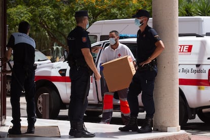 Un miembro de la Cruz Roja lleva material sanitario al Centro de Acogida, Emergencia y Derivación de la organización en Málaga.