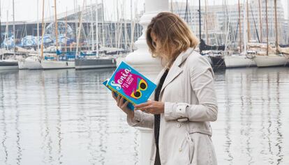 Una dona llegeix el llibre al Port Olímpic.