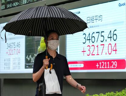 Un hombre pasa delante de un panel de resultados de la Bolsa japonesa en Tokio.