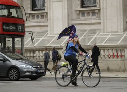 Una mujer monta su bicicleta, llevando una bandera europea y otra británica, durante una protesta cerca de la Plaza del Parlamento en el centro de Londres.