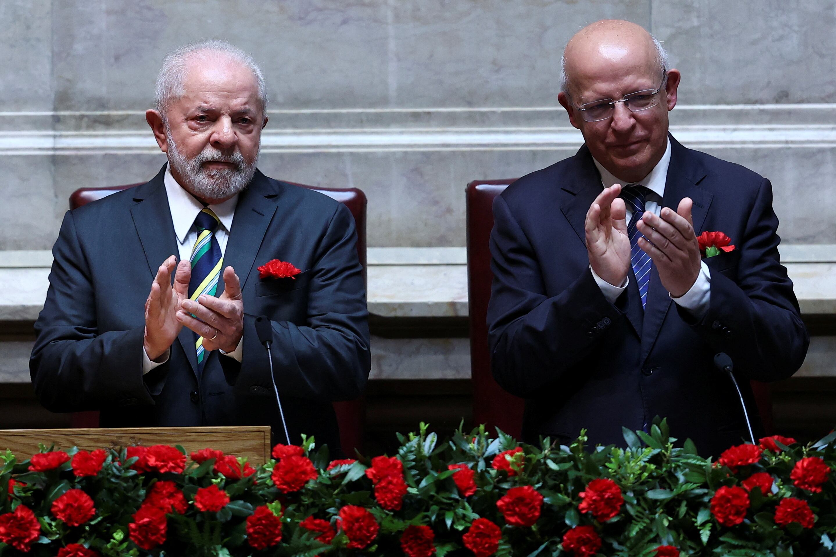 El presidente brasileño, Lula da Silva, y el presidente de la Asamblea de la República, Augusto Santos Silva, aplauden durante la sesión celebrada este martes en Lisboa. REUTERS/Rodrigo Antunes