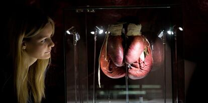 Una asistente de la exhibición observa los guantes que Muhammad Ali utilizó en su combate contra Henry Cooper en 1963.