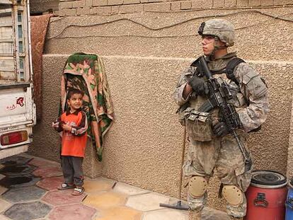 Un niño observa a un soldado estadounidense que patrulla en las calles de Ciudad Sáder, en Bagdad.