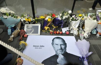 Manzanas con el mordisco típico de la marca Apple es una de las ofrendas que se amontonan junto a flores, frases y fotos en memoria de Steve Jobsen una tienda de Pekín (China).