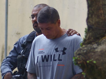 Ronnie Lessa is escorted by a police officer after testifying at the homicide department in Rio de Janeiro, in 2019.