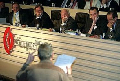 Cebrián (segundo por la izquierda) y  Polanco (tercero), escuchan a un accionista en la junta de ayer.