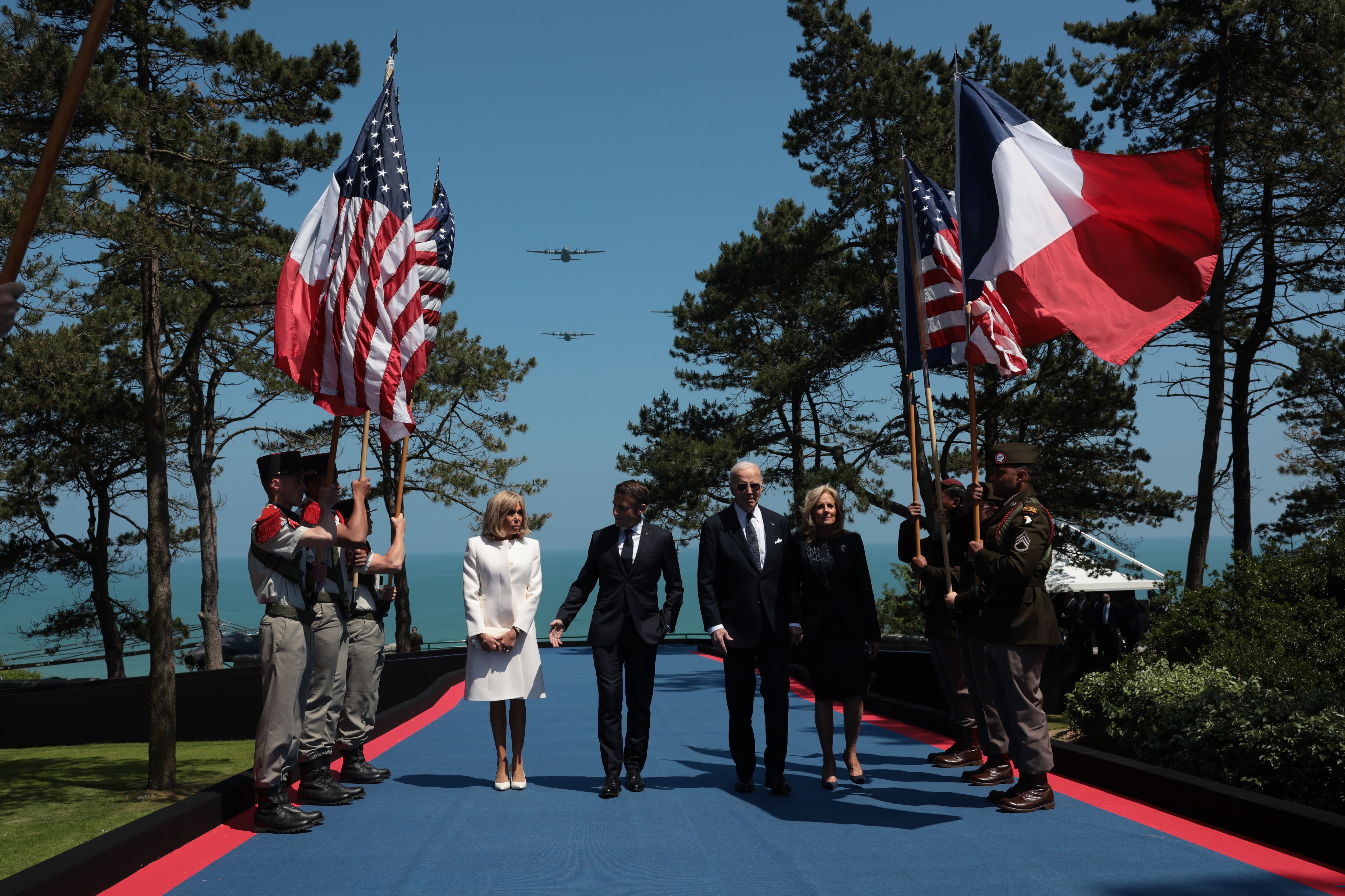 El presidente estadounidense, Joe Biden, y su mujer, Jill Biden, caminan junto al presidente de Francia, Emmanuel Macron, y su mujer, Brigitte Macron, durante su llegada a la ceremonia conmemorativa del 80º aniversario, en Normandía.