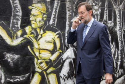 Mariano Rajoy habla por teléfono mientras camina por una calle de Pontevedra.