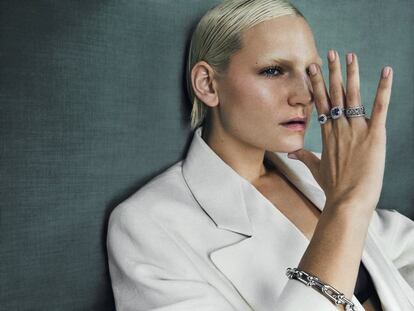 Chaqueta blanca de Wales Bonner y sujetador de Eres. Pulsera City HardWear en oro blanco y diamantes; en el dedo anular, anillo Cobblestone en platino y diamantes, y en los dedos corazón e índice, anillos modelo Soleste con diamantes y tanzanita central sobre platino. Todas las piezas son de Tiffany & Co. La modelo lleva el tono 11 Terre de Sienne de la paleta de sombra de ojos Hypnôse Palette,
de Lancôme.