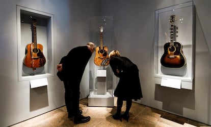 Dos personas observan la guitarra de Buddy Holly (al centro) junto a las de Wanda Jackson (izquierda) y Don Everly (derecha), que forman parte de la exposición 'Play It Loud: Instruments of Rock & Roll'. 