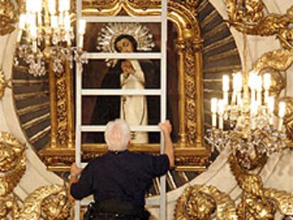 Un bombero se dispone a realizar el tradicional descenso del cuadro de la Virgen de la Paloma.
