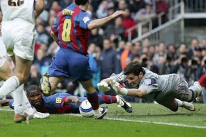 Casillas se lanza a los pies de Giuly, con Eto'o caído en el suelo.