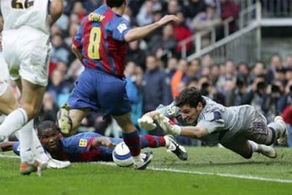 Casillas se lanza a los pies de Giuly, con Eto'o caído en el suelo.