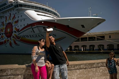 Cubanos se toman una foto frente aun crucero atracado en La Habana, en 2019. 