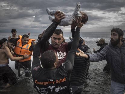 Un voluntario sostiene a un bebé en las costas griegas de Lesbos.