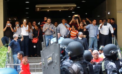 Moradores da região tiram fotos do confronto entre manifestantes e policiais.