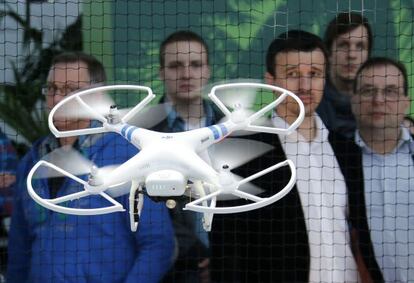 Los asistentes a la feria CeBIT de Hanover (Alemania) contemplan un dron Phantom 2.