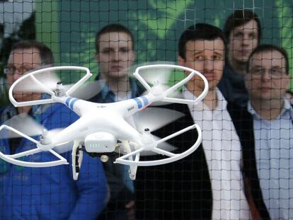 Los asistentes a la feria CeBIT de Hanover (Alemania) contemplan un dron Phantom 2.