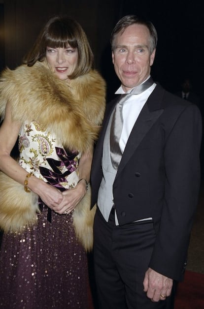 Para acertar con el 'dress code' de la gala del museo neoyorquino en 1990, el estilo roquero, Wintour eligió este modelo de 'paillettes' y una estola de pelo. En la imagen aparece junto al diseñador Tommy Hilfiger.