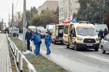 Miembros de los servicios de emergencia al lado del cuerpo sin vida de una persona, tras el ataque contra un centro escolar de la ciudad de Izhevsk.