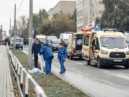 Miembros de los servicios de emergencia al lado del cuerpo sin vida de una persona, tras el ataque contra un centro escolar de la ciudad de Izhevsk.
