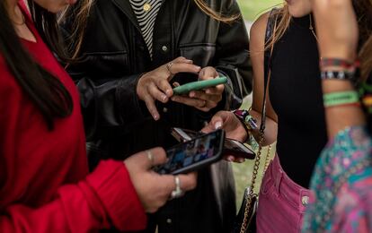 Un grupo de chicas jóvenes utilizan sus teléfonos móviles.