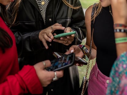 Un grupo de chicas jóvenes utilizan sus teléfonos móviles.