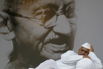 Anna Hazare descansa delante de un retrato gigante de Mahatma Gandhi.