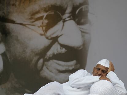 Anna Hazare descansa delante de un retrato gigante de Mahatma Gandhi.