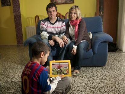 David y Cruz, los padres de Jonathan, sentado en el suelo, en su domicilio de Vinaròs.