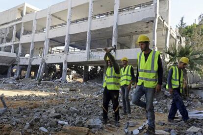 Trabajadores palestinos limpian esgombros de una escuela de la UNRWA, en Gaza, destruida durante el reciente conflicto entre Israel y Ham&aacute;s. 