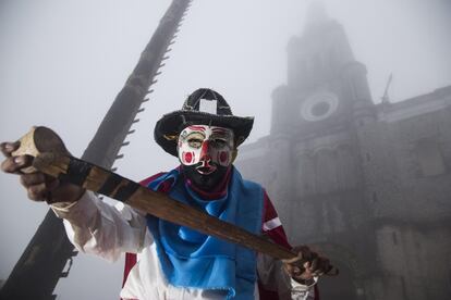 Un hombre muestra una espada de madera durante la procesión de la Reina Huipil, celebrado en la comunidad náhualt de Cuetzalan, Puebla, (México).