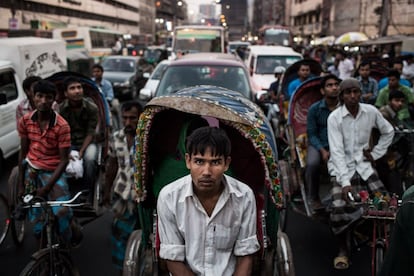 El conductor de un 'rickshaw' espera en medio de un intenso atasco en el distrito de Mothijeel. Los masivos atascos de tráfico son un escenario común en Dhaka, así como un importante problema para la ciudad.