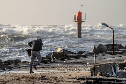 person struggles against the wind at Thorsminde Harbour, in the west coast of Jutland, Denmark, 21 December 2023