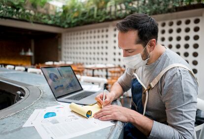 Business manager wearing a facemask while doing the books at a restaurant