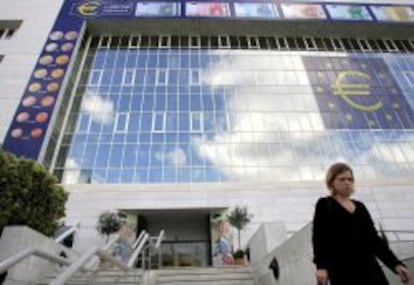 Una mujer chipriota camina delante de un enorme s&iacute;mbolo del euro en la fachada del Banco Central en Nicosia, Chipre. 