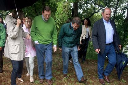 Mariano Rajoy in Galicia on Saturday next to regional premier Alberto N&uacute;&ntilde;ez Feij&oacute;o (stooping).