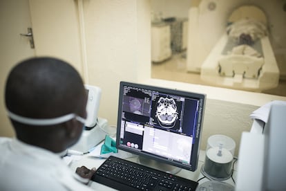 Um médico prepara um paciente de 90 anos para uma tomografia computadorizada no Hospital Central da Beira em 9 de março de 2020. “Há desafios de infraestrutura, o centro tem 125 anos e foi parcialmente destruído por ciclones como o Idai, de março de 2019. Como foi crescendo, os serviços estão distantes um do outro. As áreas de esterilização estão fechadas e, sempre que chove, alagam. Não temos enfermeiras especializadas. Precisamos também de meios de diagnóstico: não temos tomografia e nunca tivemos ressonância”, enumera Bonifácio Cebola, diretor pedagógico do centro.